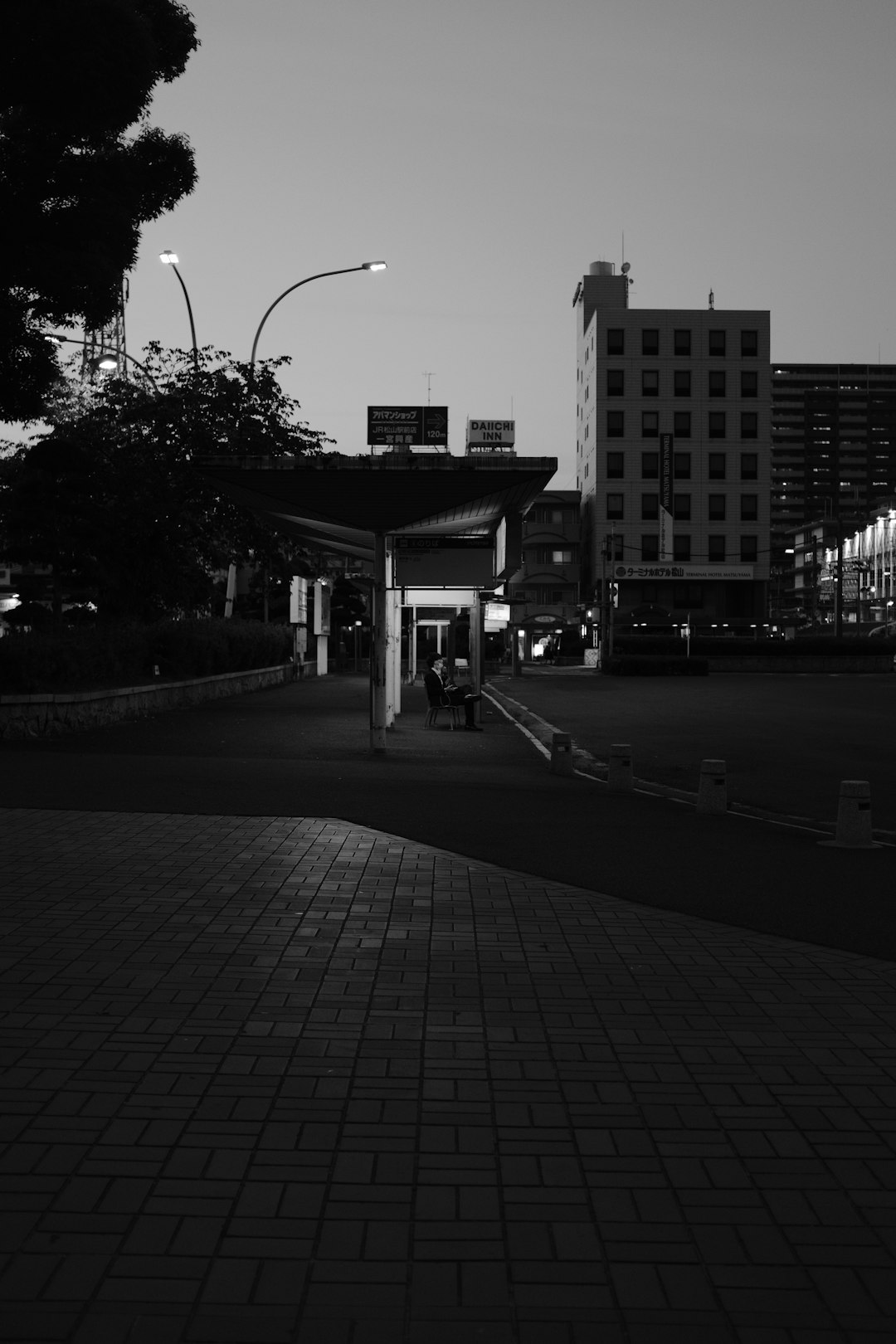 grayscale photo of people walking on sidewalk near building