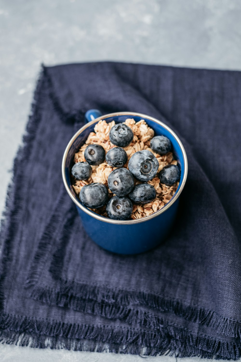 brown and black round fruits in blue ceramic bowl