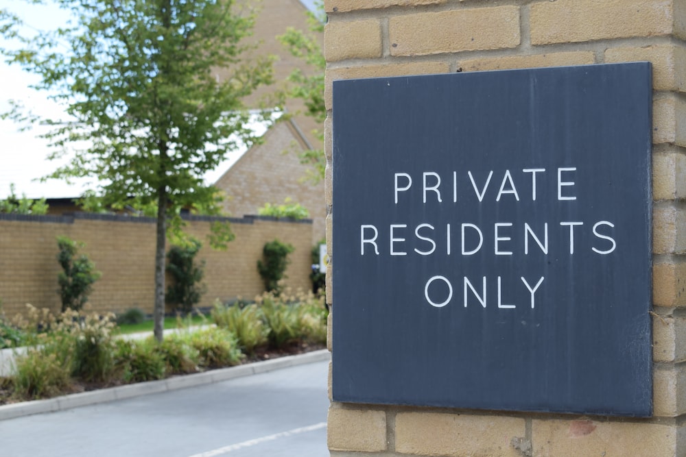 a sign on a brick wall that says private residents only