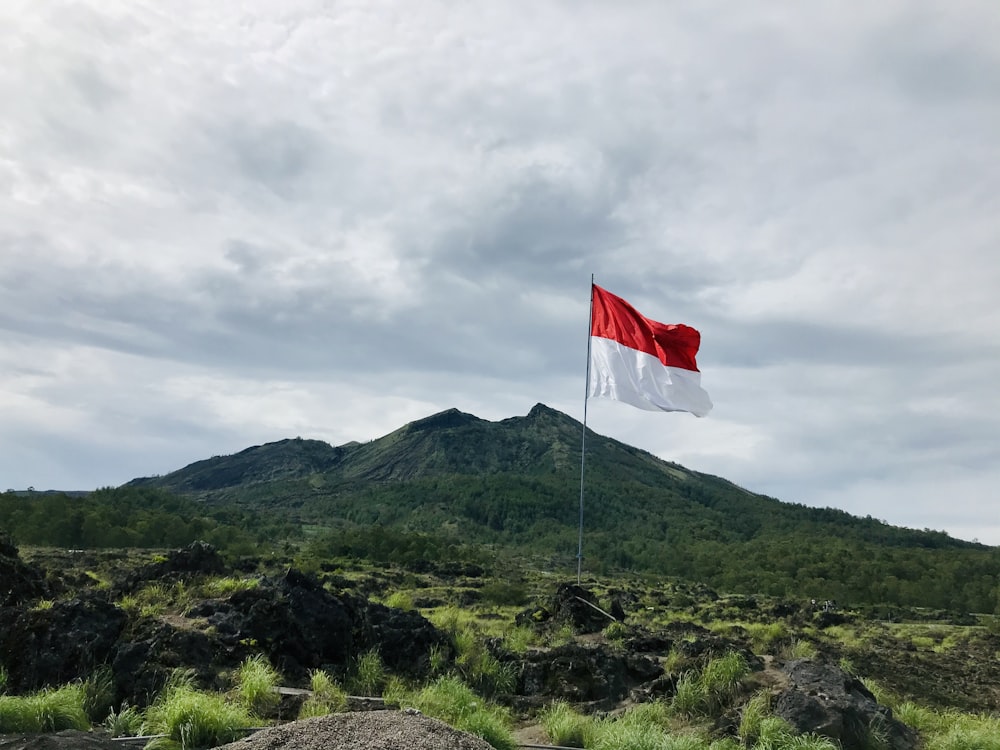 red and white flag on top of mountain