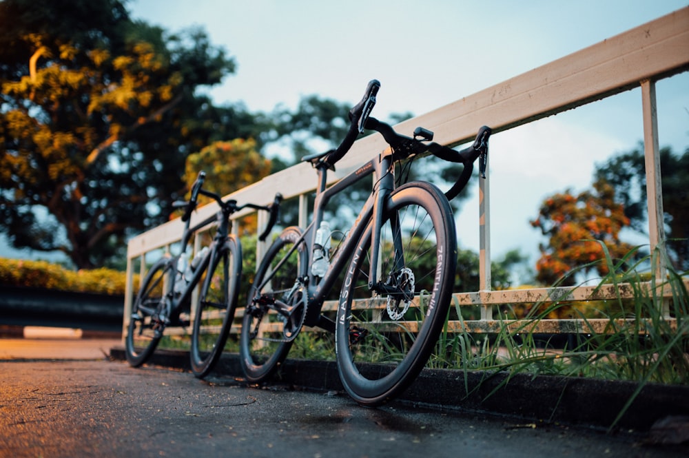 black bicycle on brown wooden fence during daytime