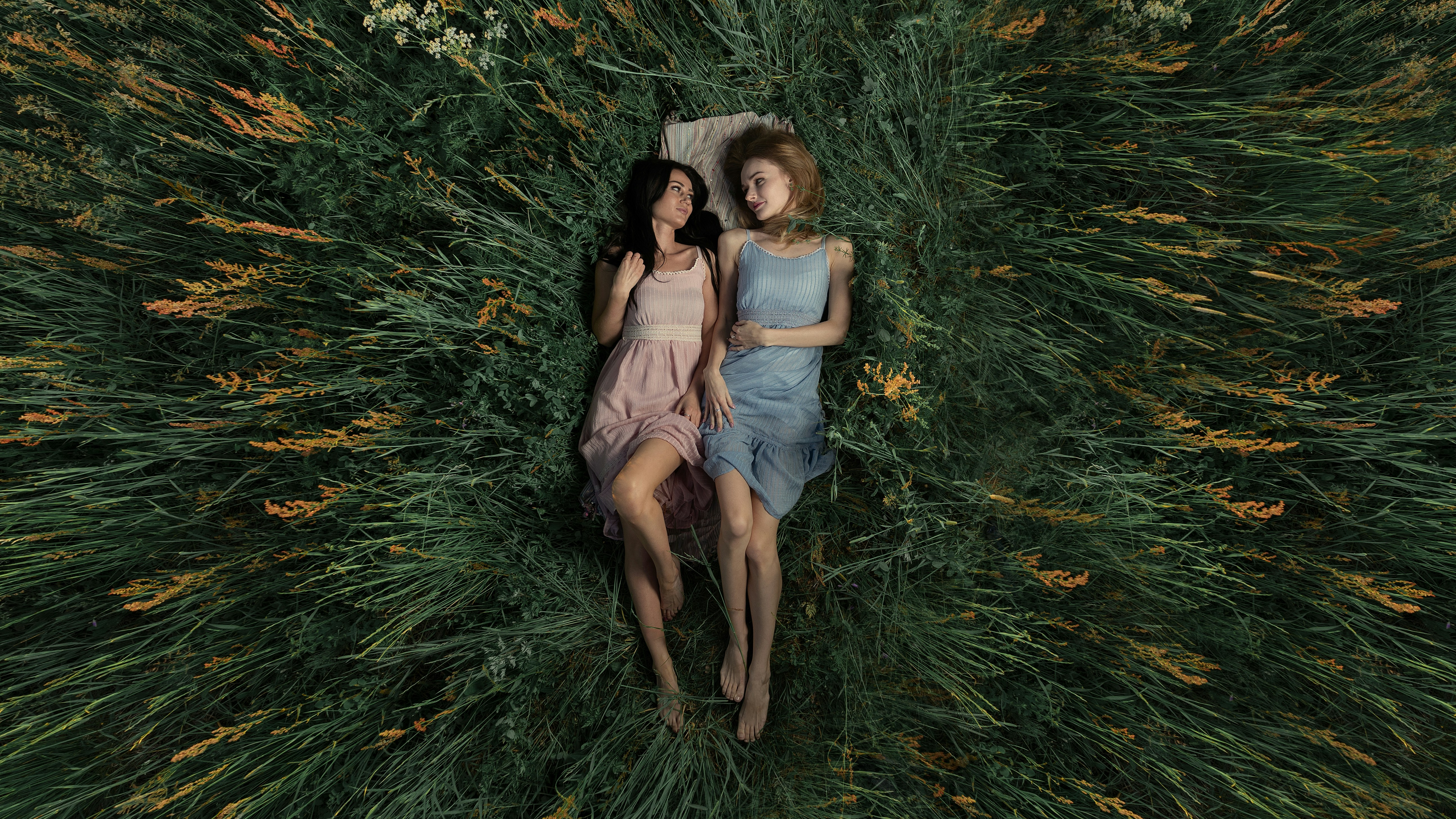 2 women sitting on green grass
