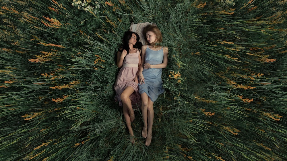 2 women sitting on green grass