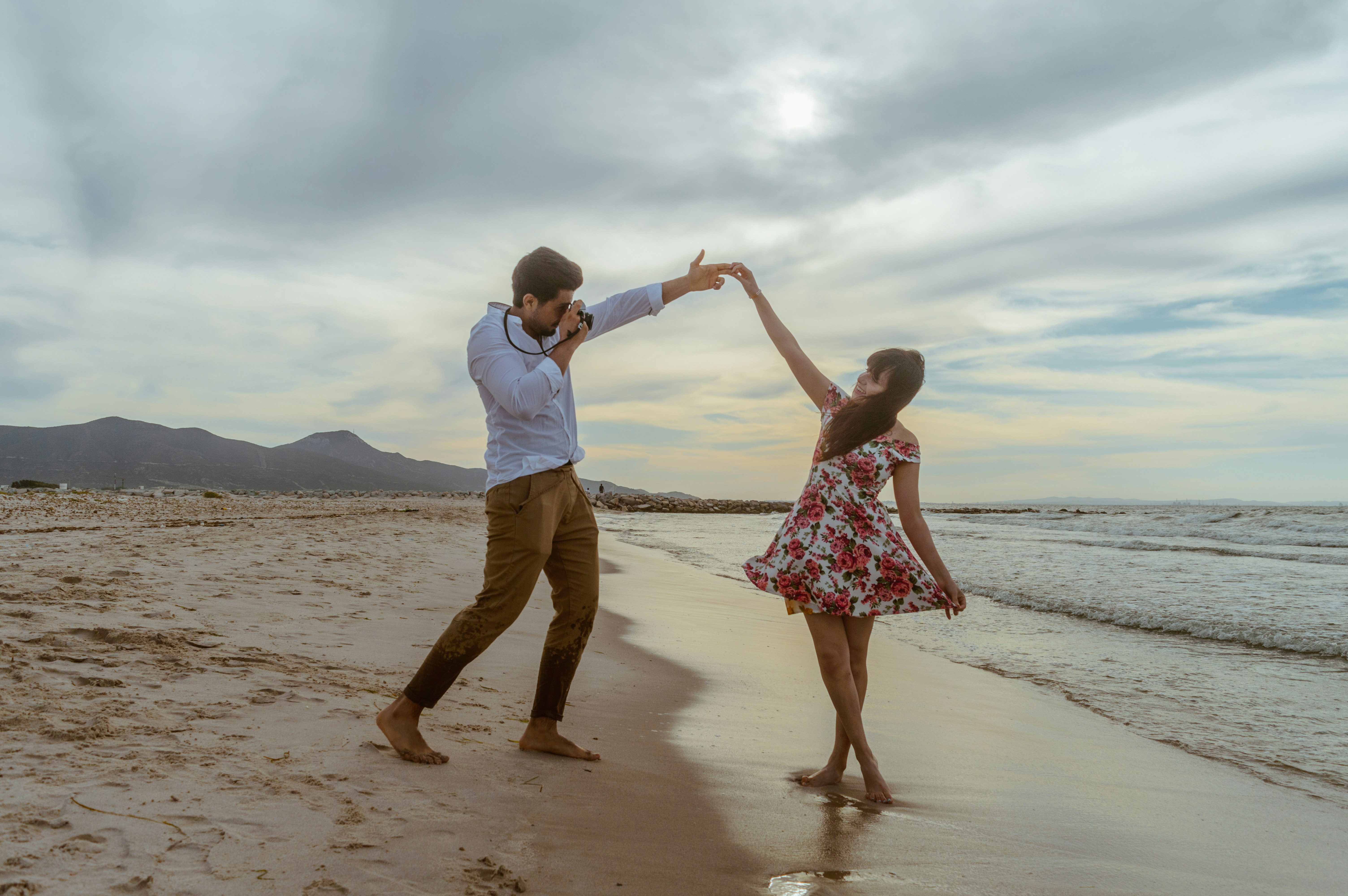 man and woman walking on beach during daytime