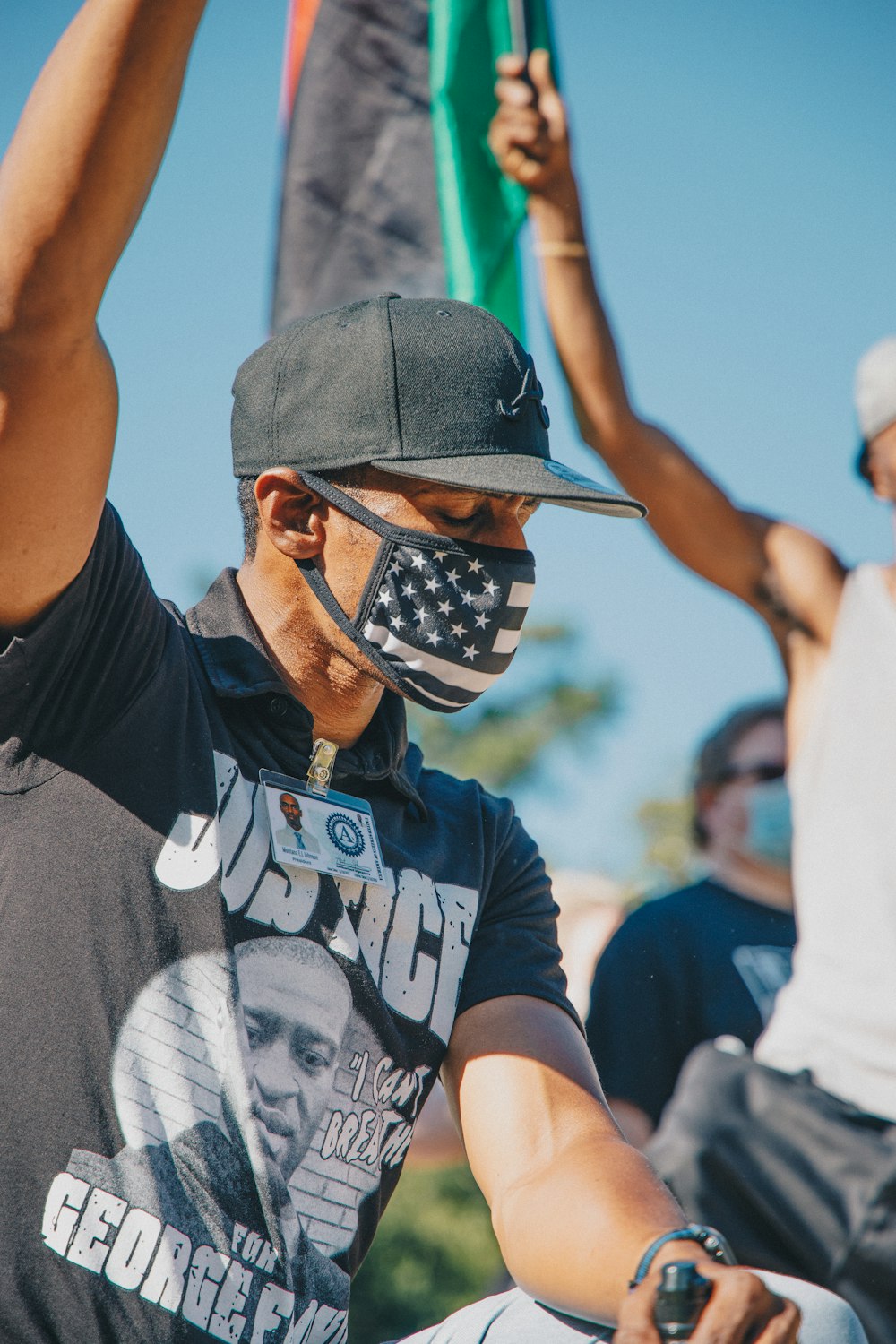 man in black and white crew neck t-shirt wearing black sunglasses and black cap