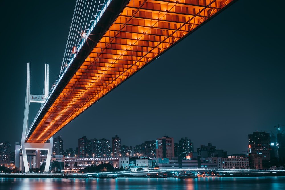 lighted bridge over body of water during night time