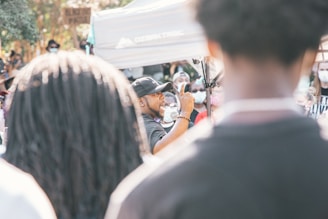 A speaker passionately addressing a crowd outdoors.