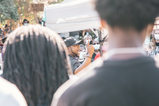 A speaker passionately addressing a crowd outdoors.