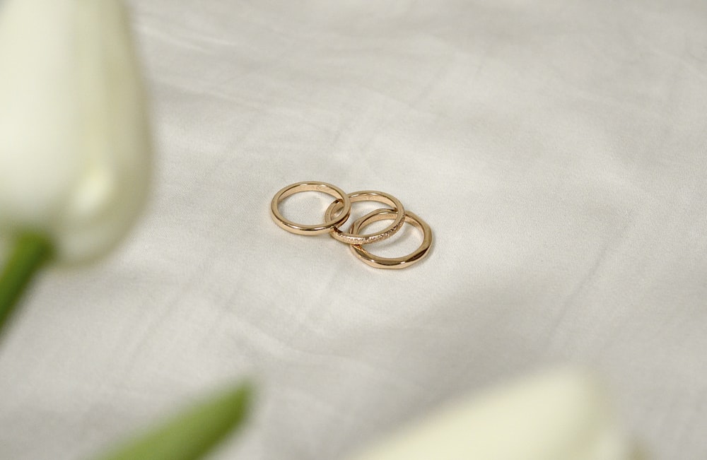 gold ring on white textile