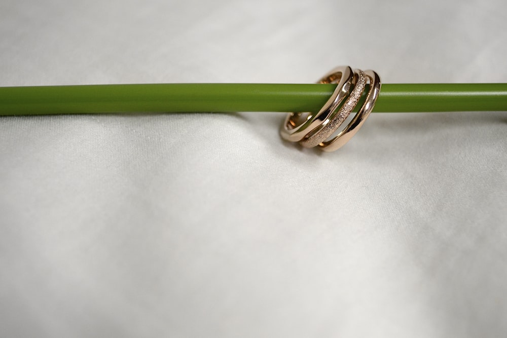 gold and silver ring on white textile