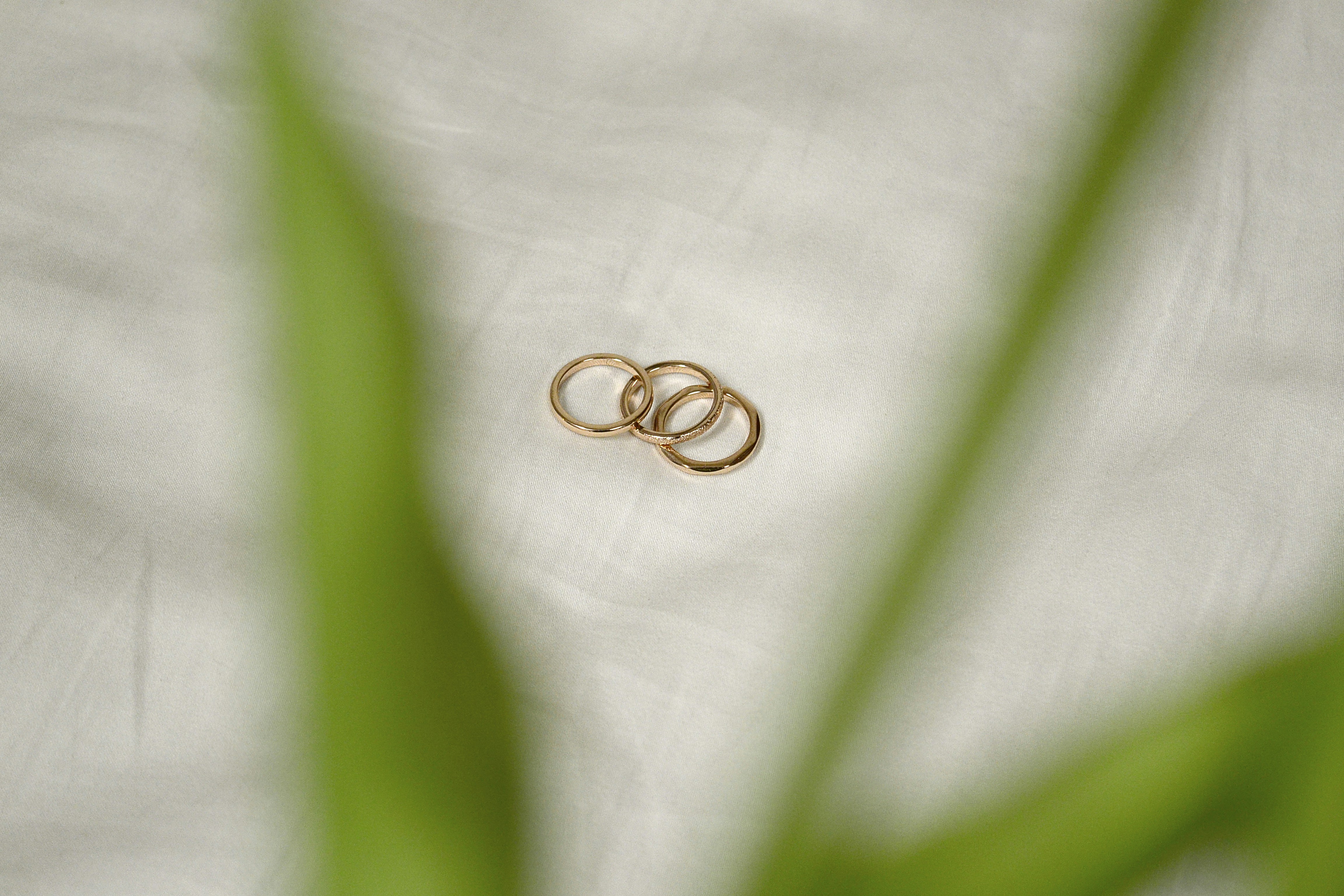 gold wedding band on white textile