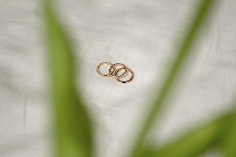 gold wedding band on white textile