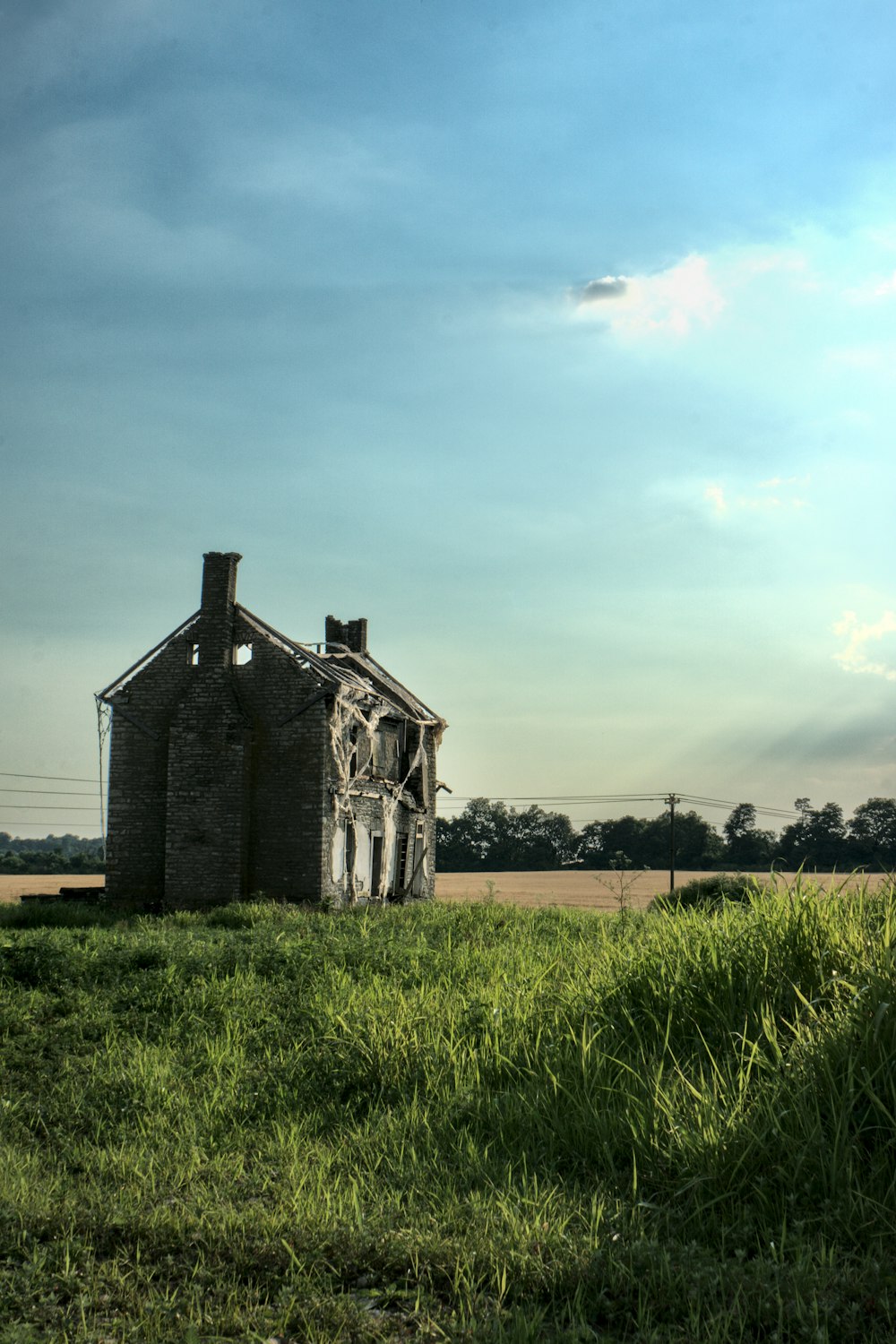 gray concrete house on green grass field under gray sky