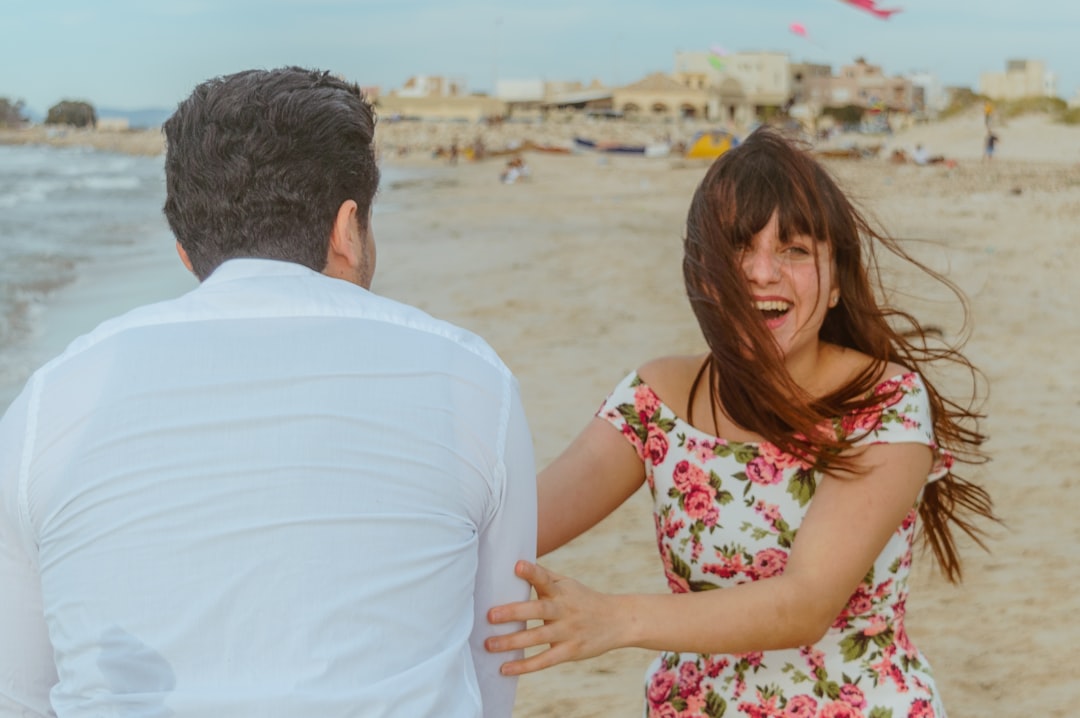 man and woman kissing on beach during daytime