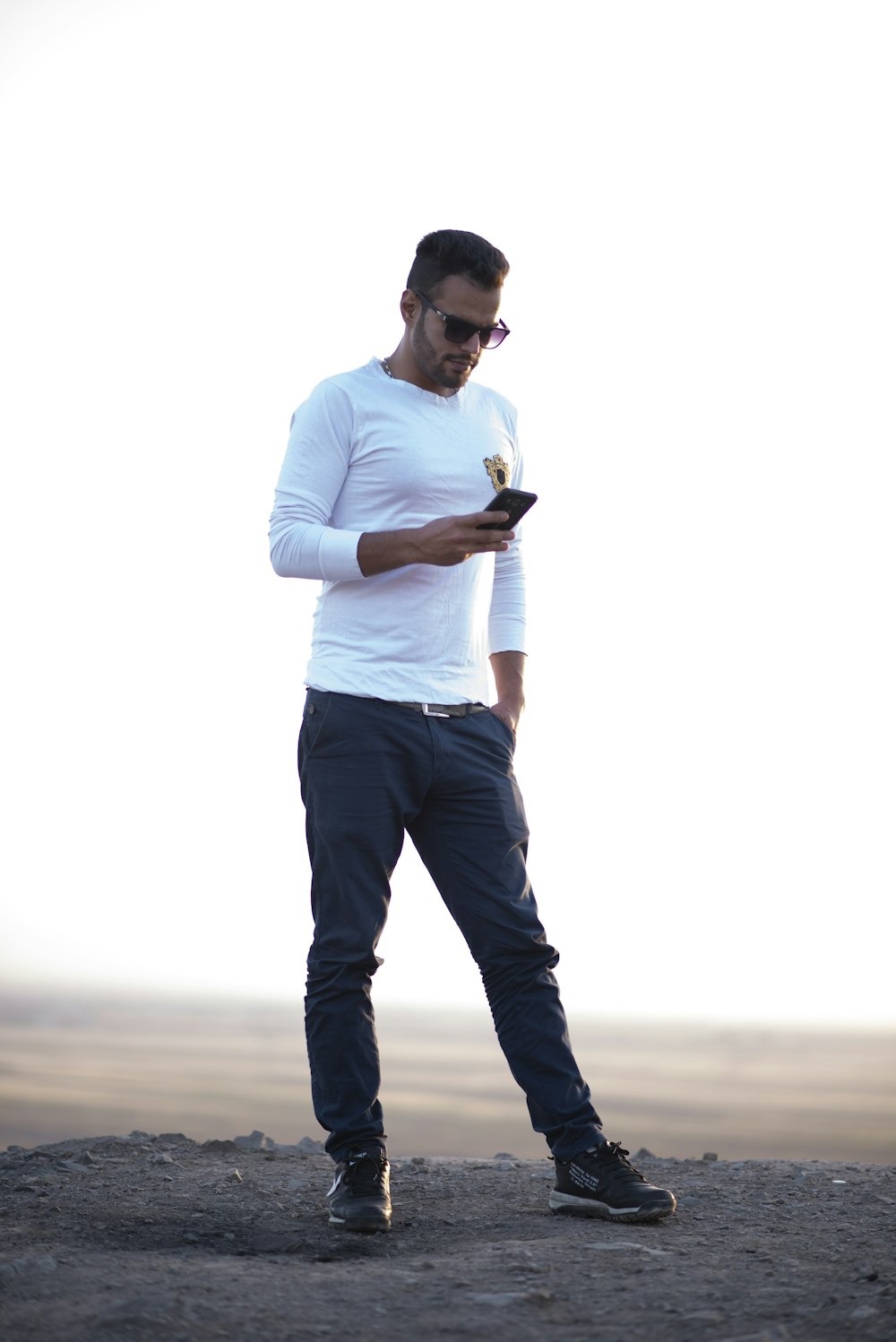 man in white dress shirt and black pants standing on gray asphalt road during daytime