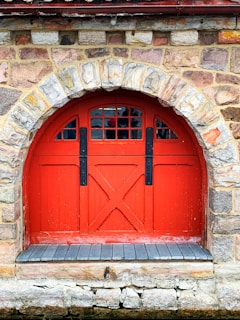 red wooden door on brown brick wall