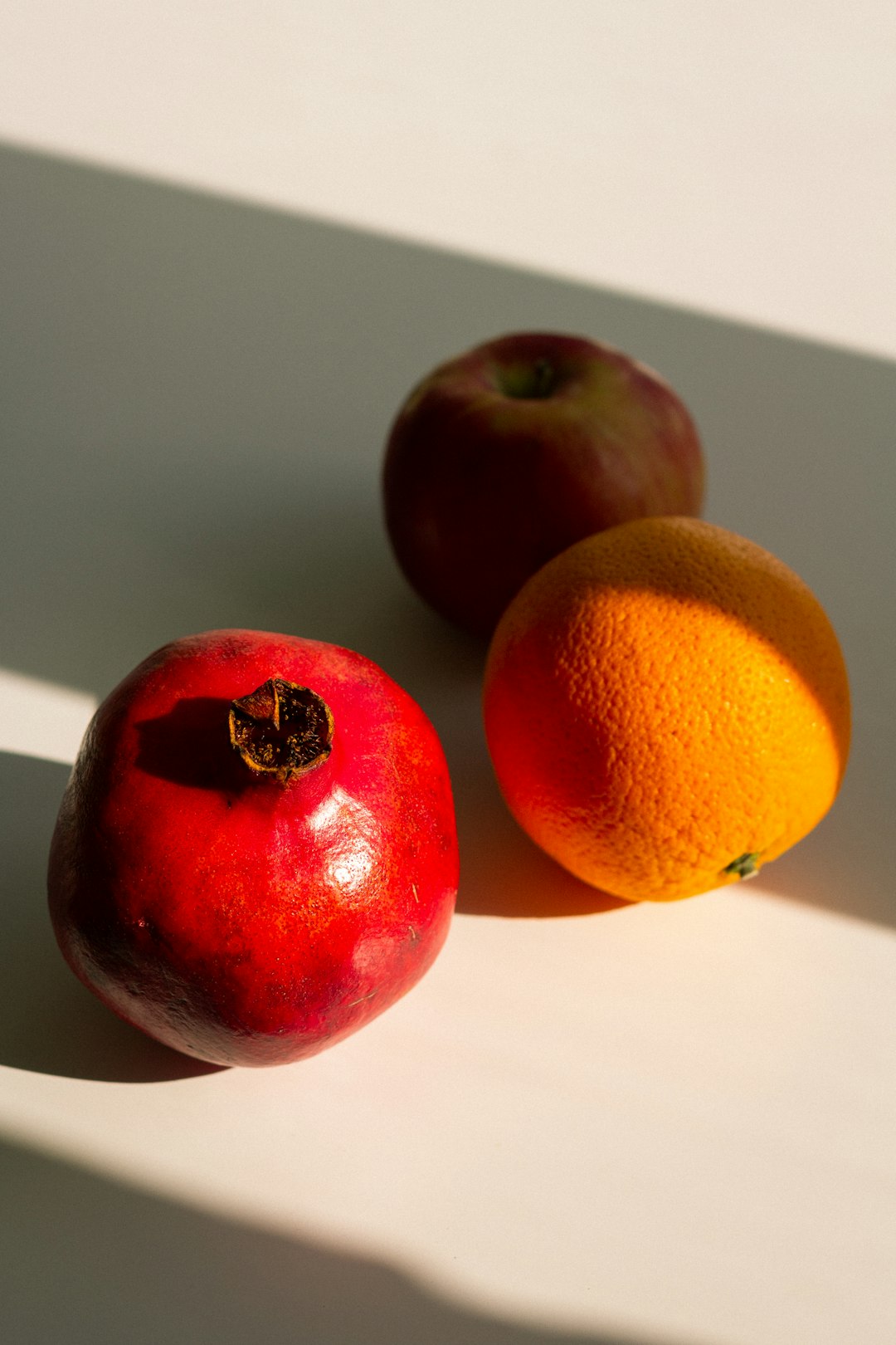 orange and apple fruits on white table