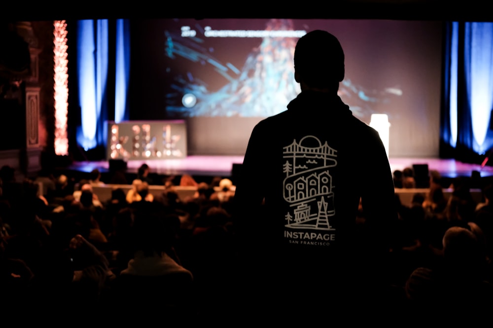 man in black crew neck shirt standing on stage