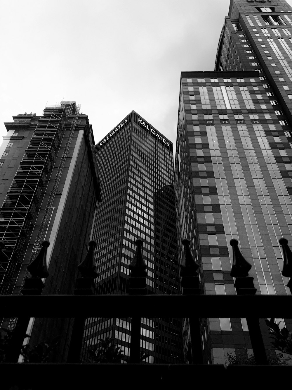 grayscale photo of man and woman kissing on top of building