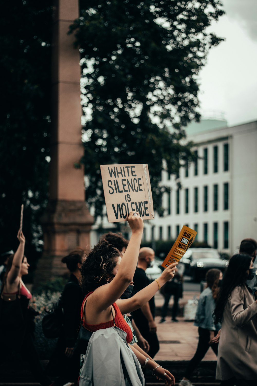 people holding white and black street sign during daytime