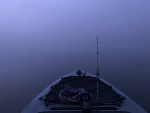 A serene fishing scene with a kayak on calm waters.