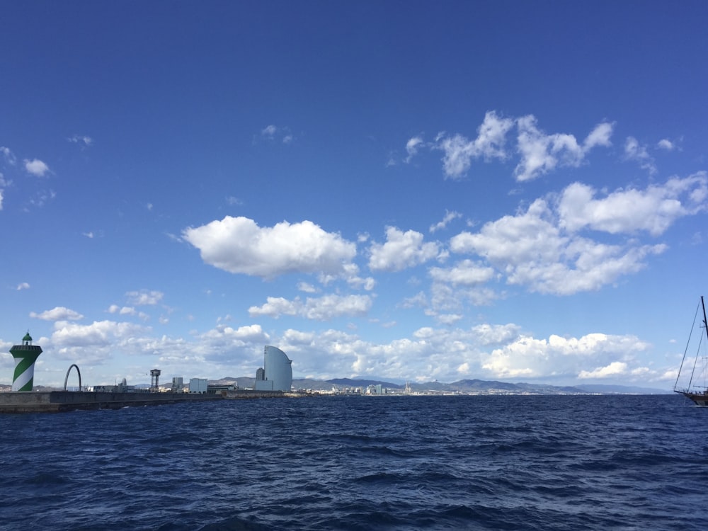 white ship on sea under blue sky and white clouds during daytime