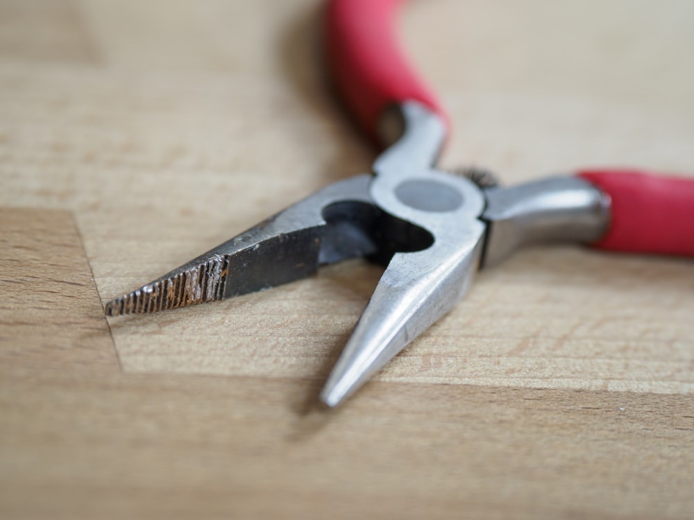 red and silver scissors on brown wooden table