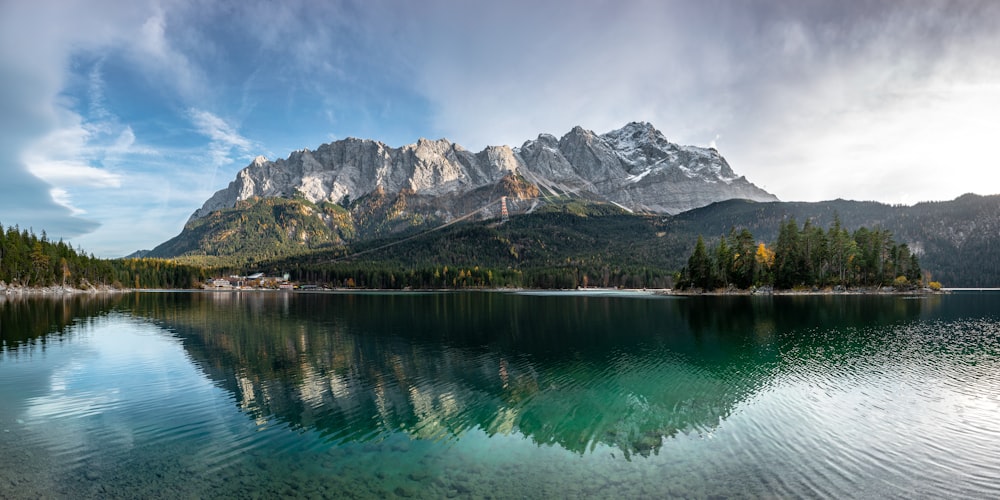 green lake near mountain under blue sky during daytime