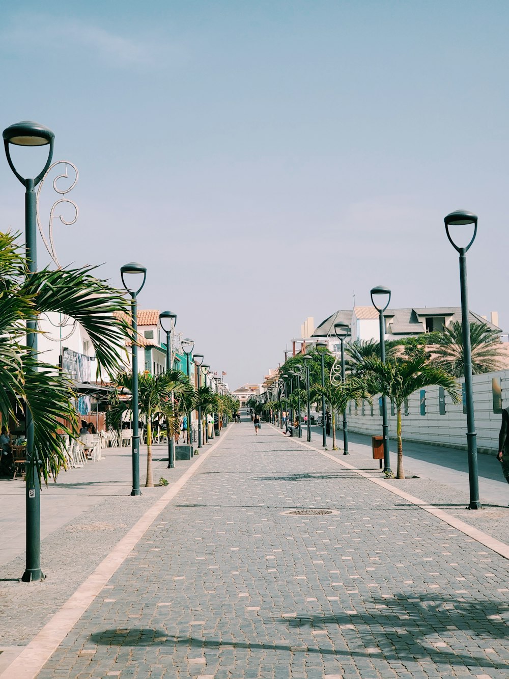 black street lamp on gray concrete pathway during daytime