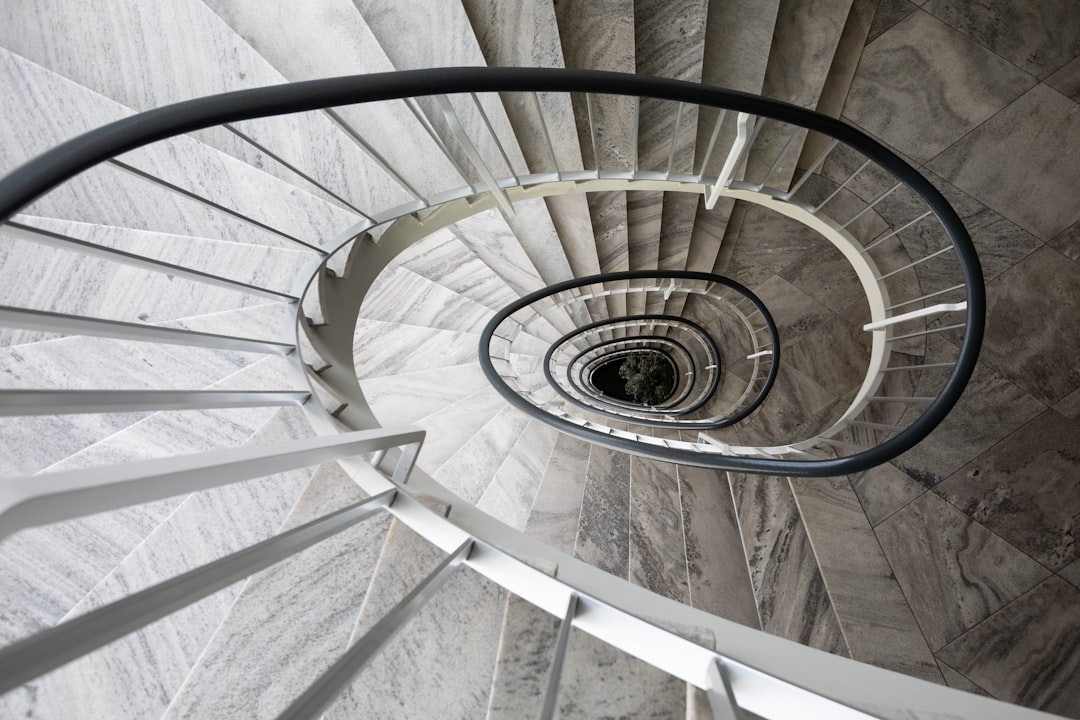 white spiral staircase with gray metal railings