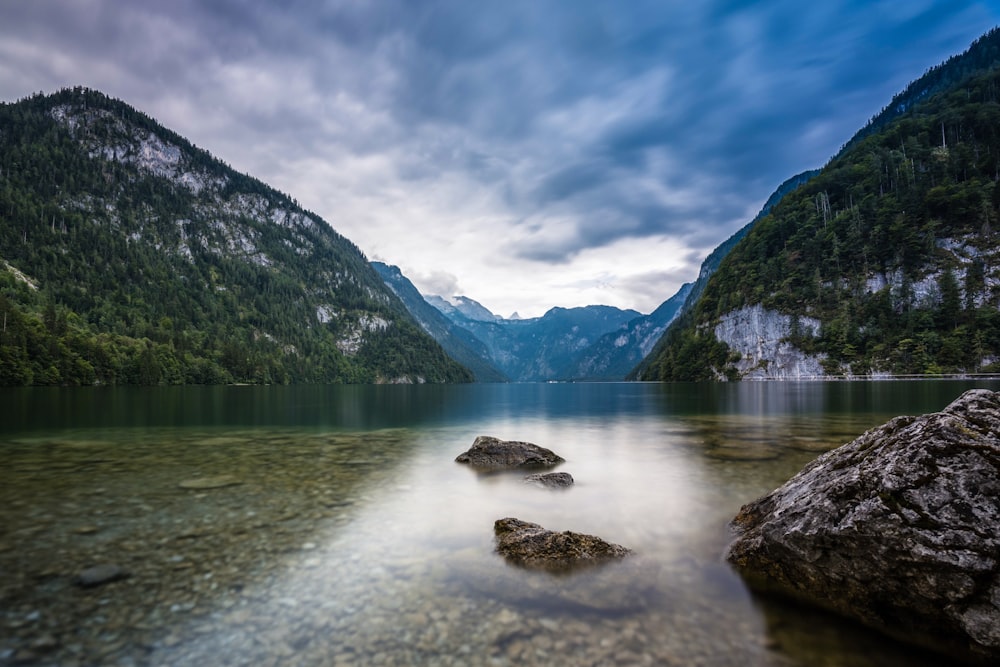 green mountains beside lake under blue sky during daytime