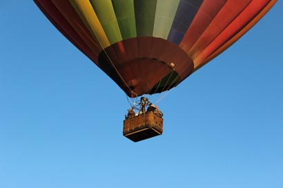 orange and yellow hot air balloon in mid air during daytime