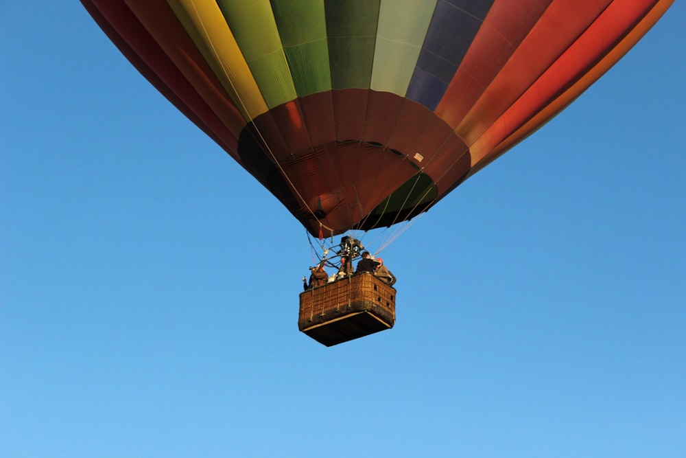 orangefarbener und gelber Heißluftballon in der Luft während des Tages