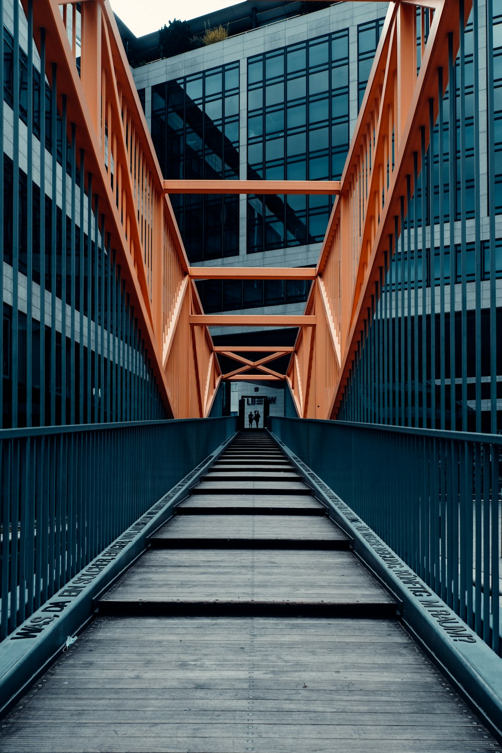 brown wooden bridge with stainless steel railings