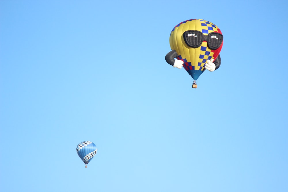 yellow and black hot air balloon in mid air during daytime