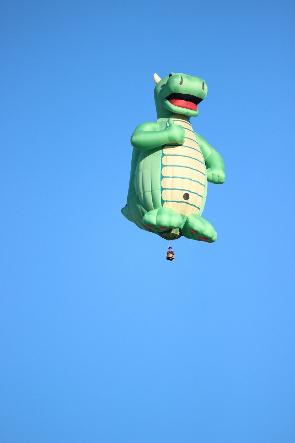 grenouille verte avec écharpe à pois bleu et blanc