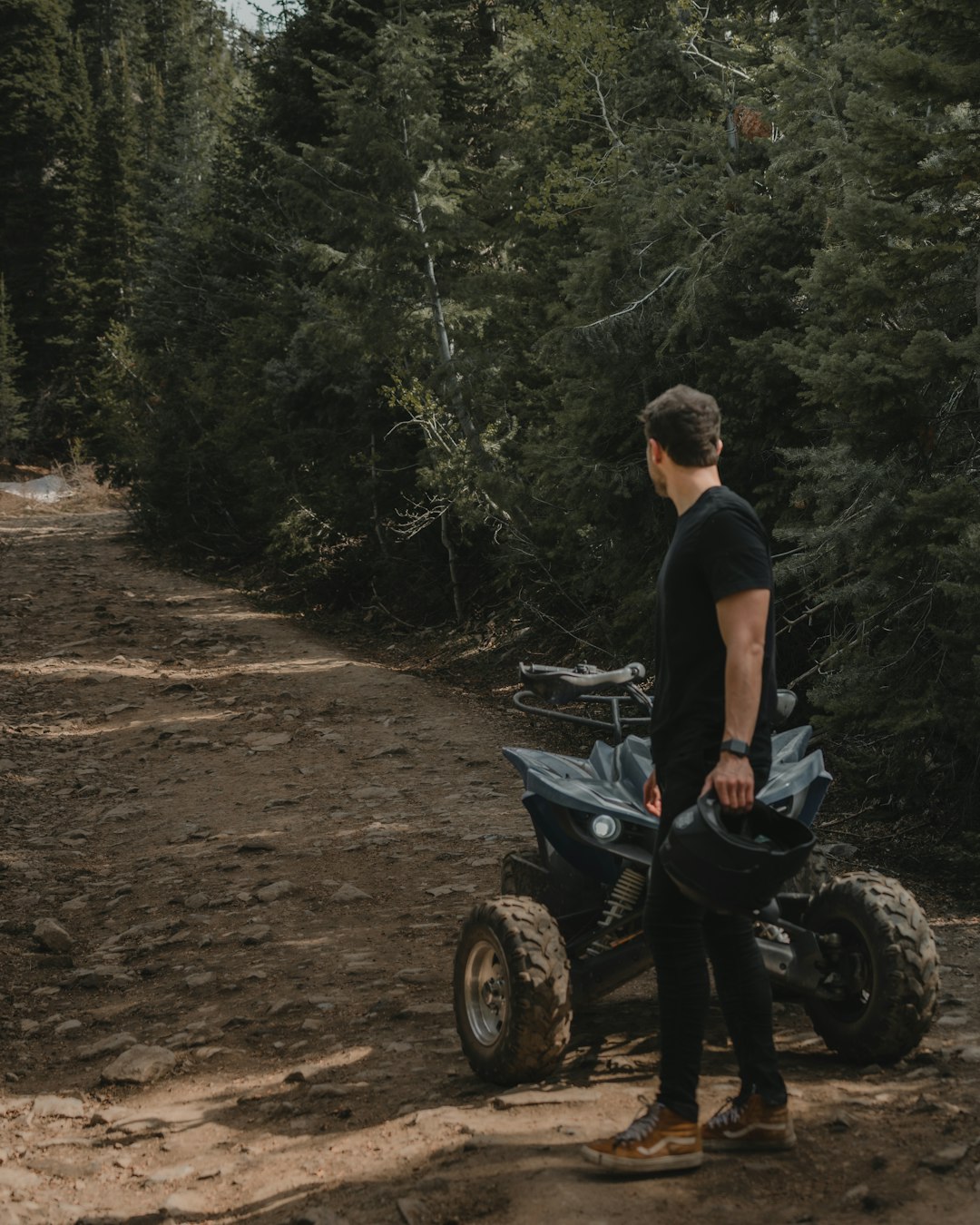 man in black t-shirt and blue denim jeans sitting on black motorcycle during daytime