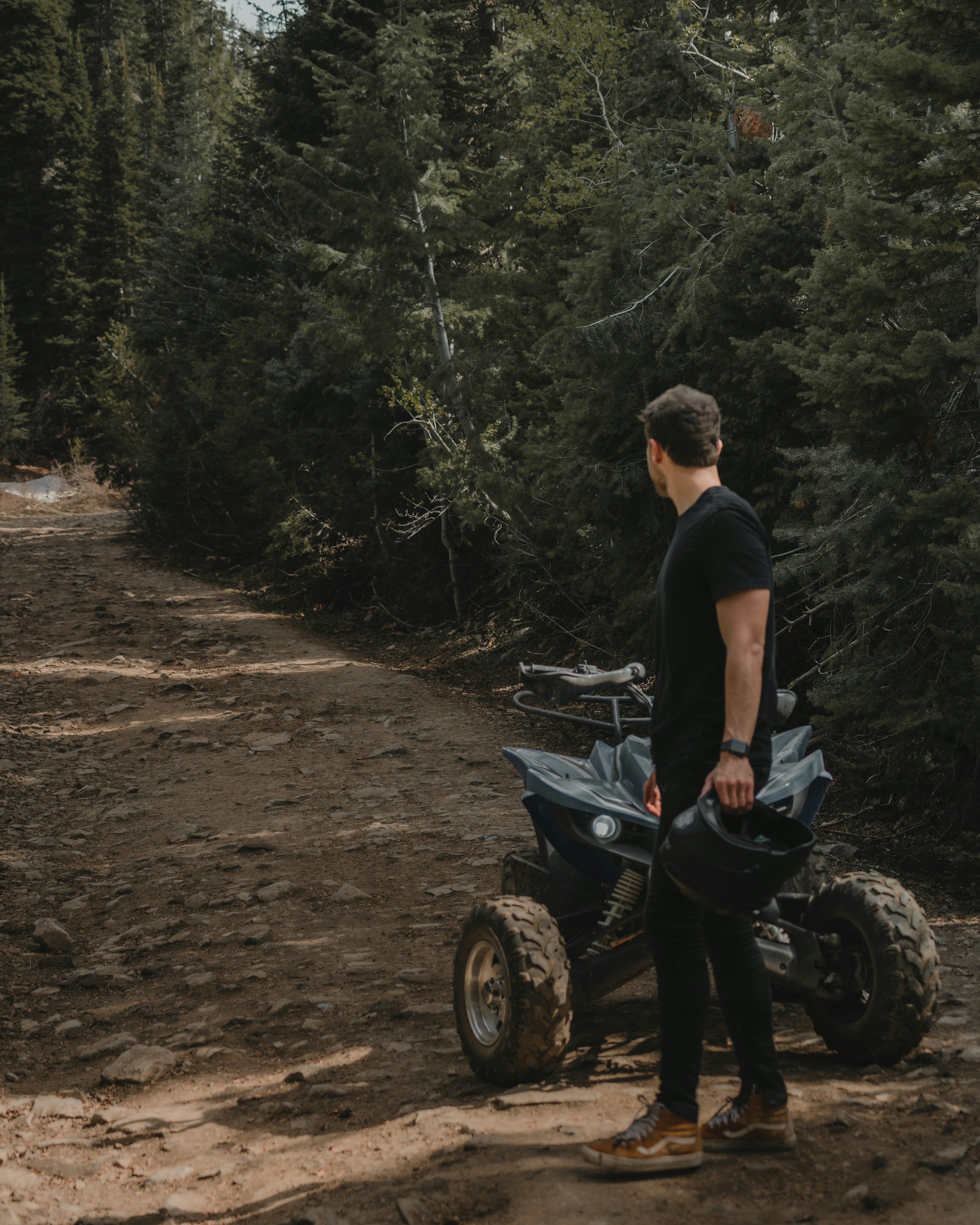 man in black t-shirt and blue denim jeans sitting on black motorcycle during daytime