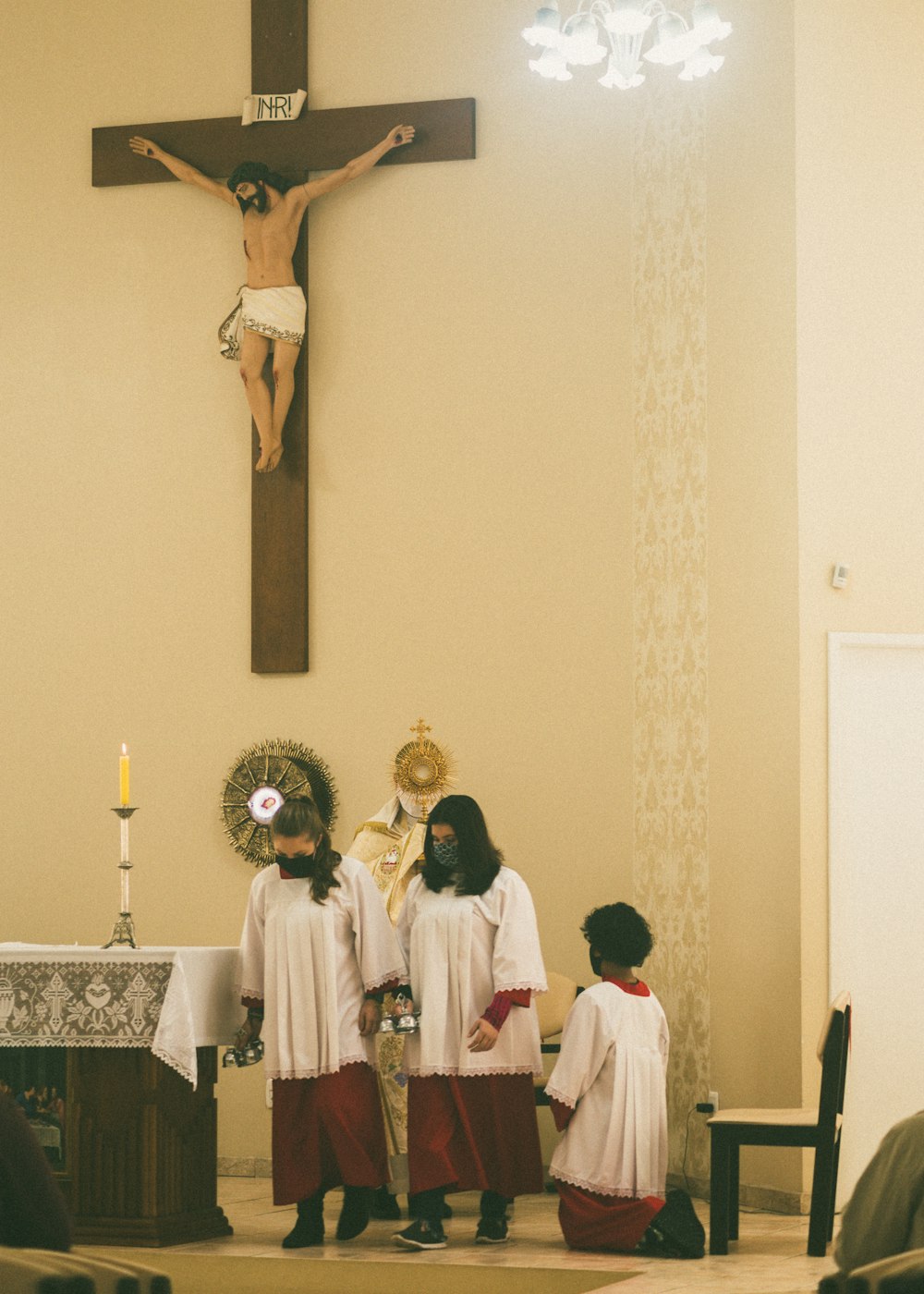 people in white robe standing in front of jesus christ statue