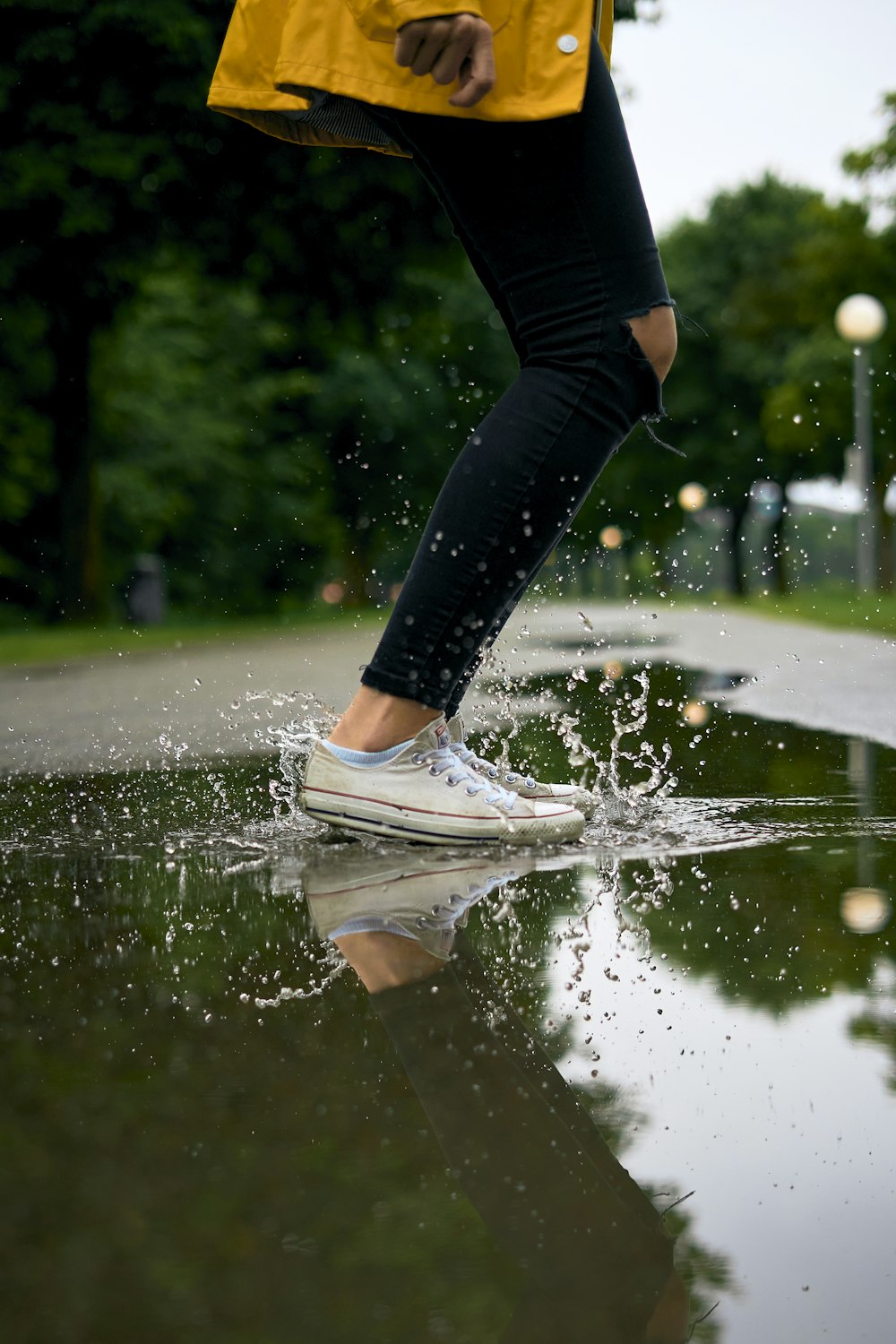 person in black leggings and white sneakers jumping on water