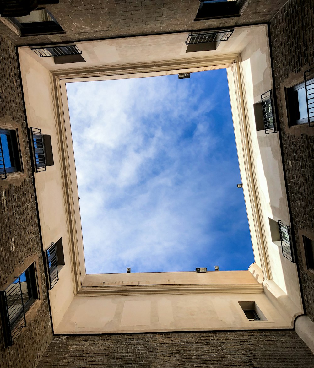 brown brick building under blue sky and white clouds during daytime