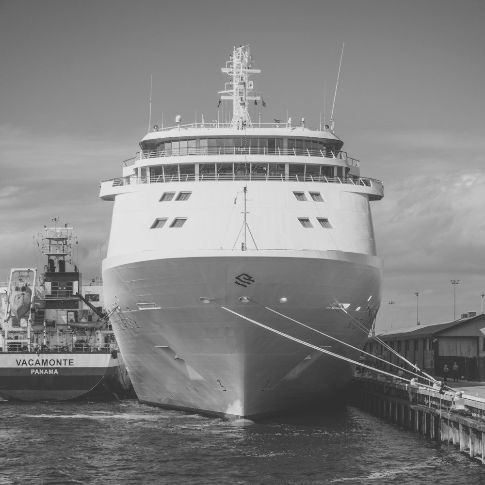 grayscale photo of ship on dock