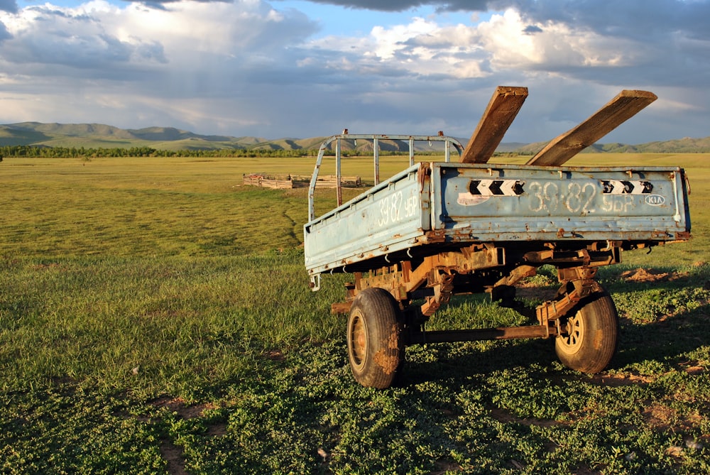 Camión utilitario marrón y blanco en un campo de hierba verde bajo el cielo azul durante el día