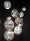 Close-up of a bohemian beaded pendant light casting warm patterns on the wall.