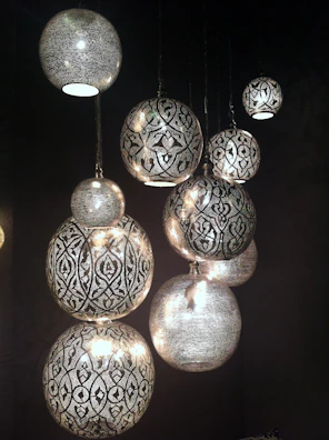 Close-up of a bohemian beaded pendant light casting warm patterns on the wall.