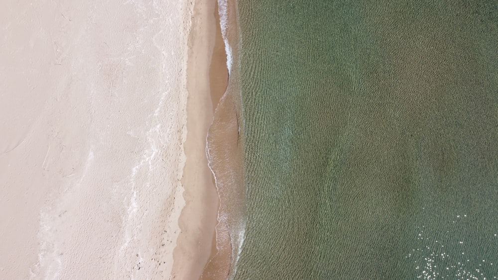 white and green textile beside white sand