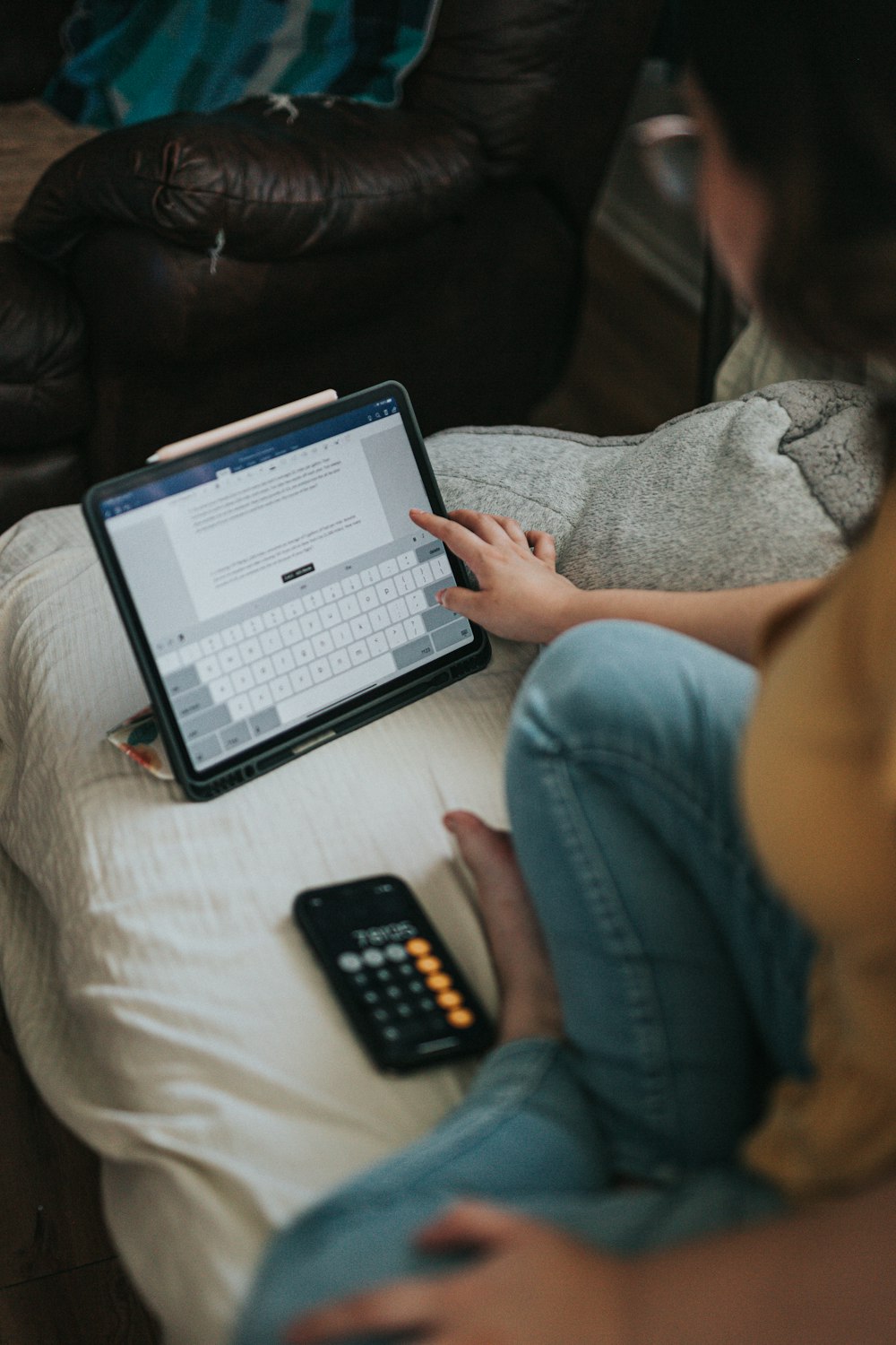 person in blue denim jeans using black and white laptop computer