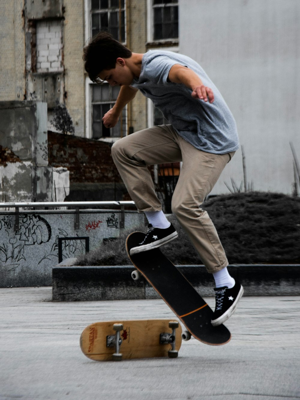 man in gray shirt and black pants riding skateboard during daytime