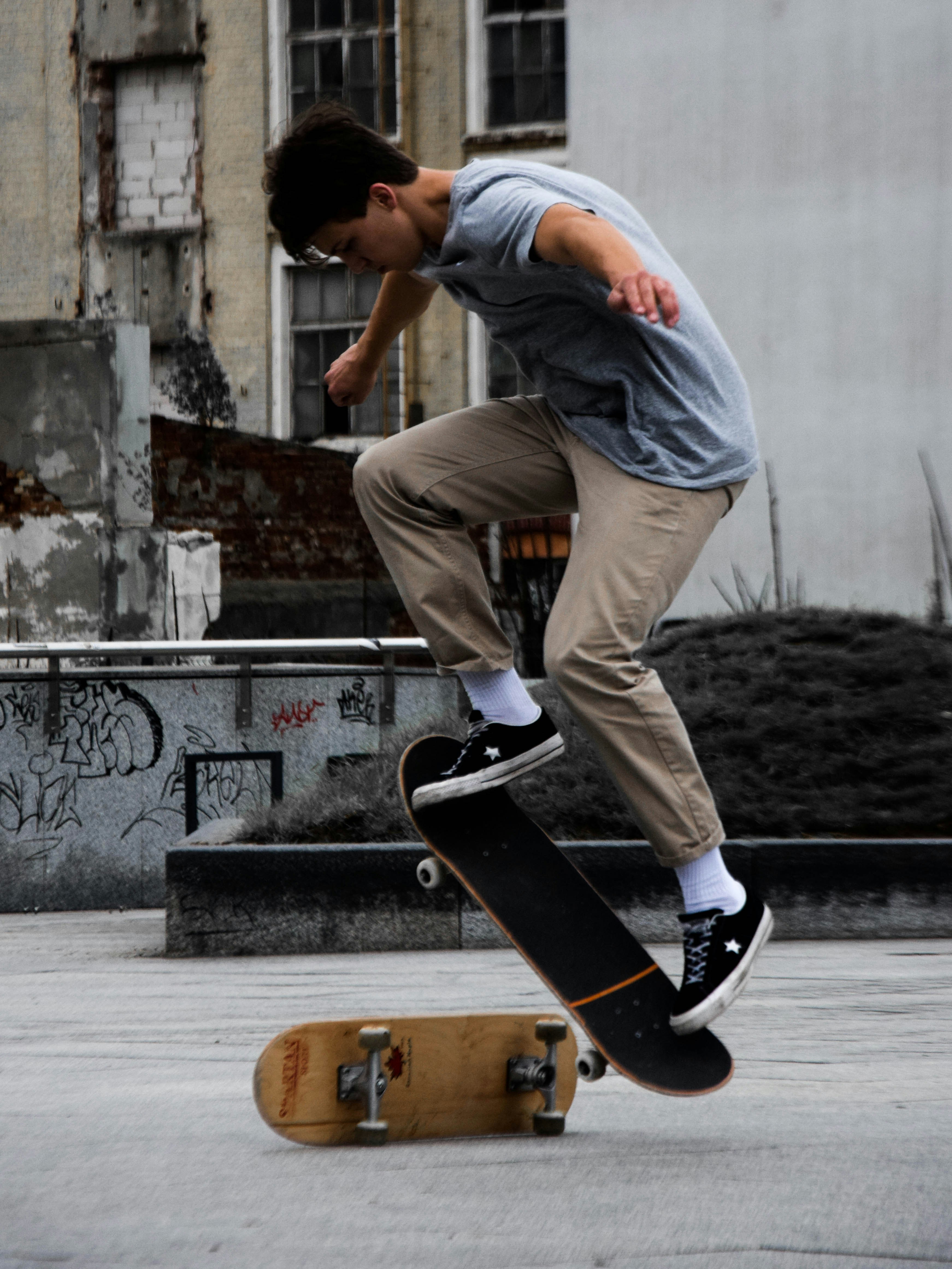 man in gray shirt and black pants riding skateboard during daytime