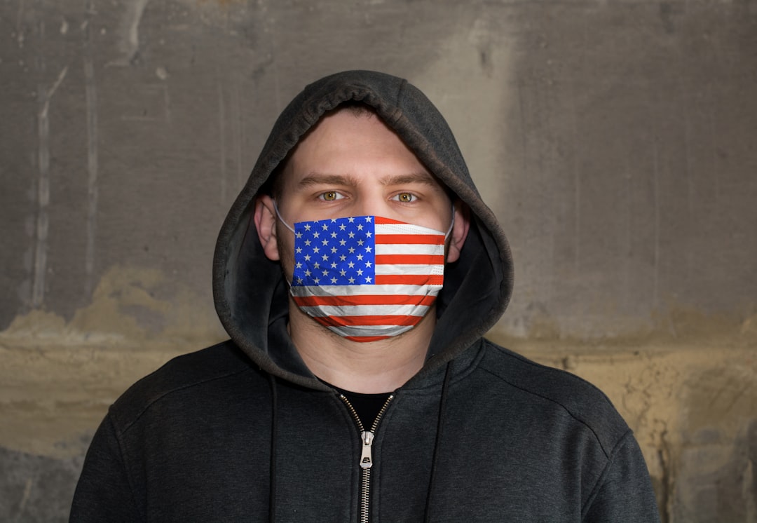 Man Wearing a hood and a USA flag Mask to Protect him